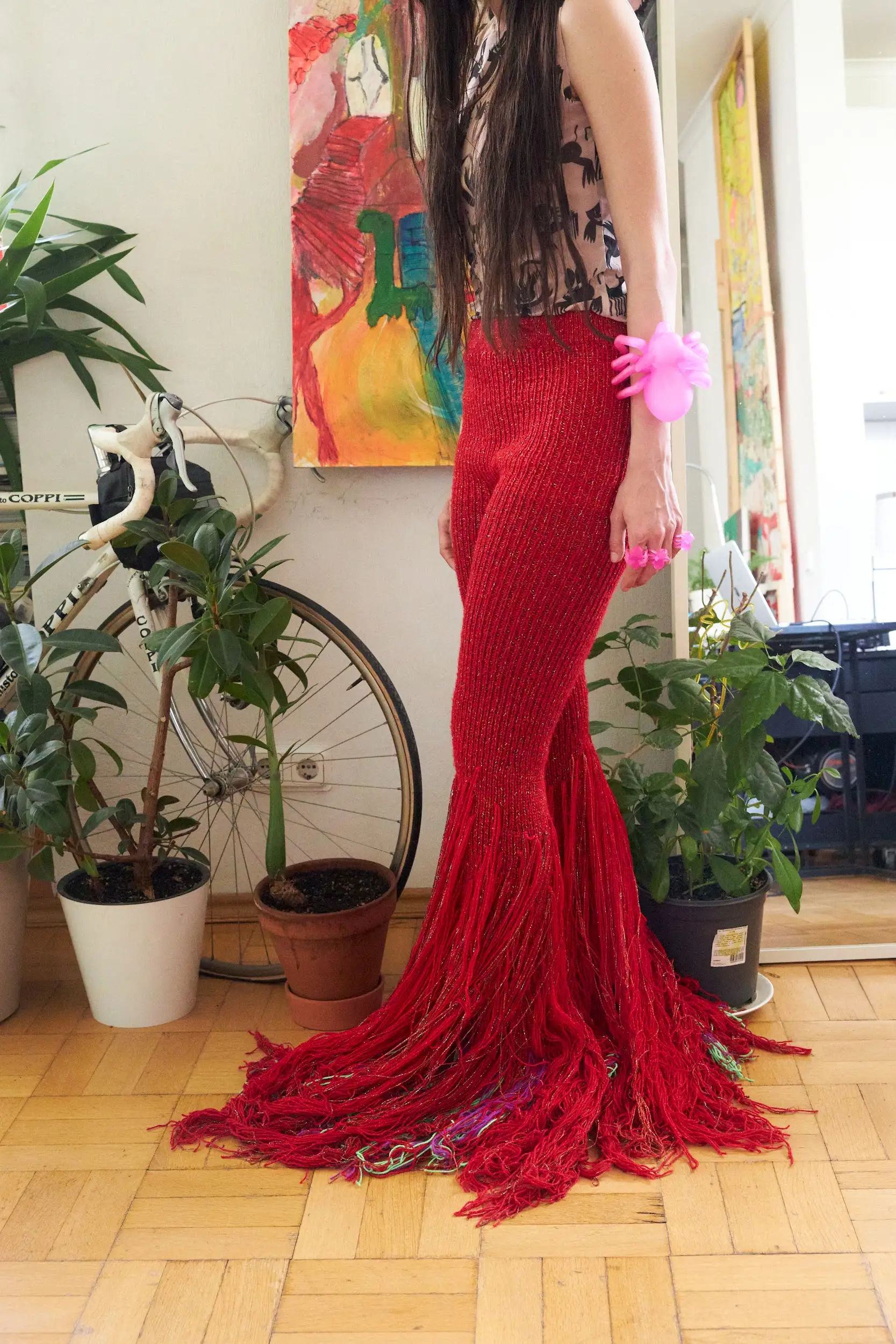 Ярко-красные брюки ручной вязки с длинной бахромой и блестящей нитью. Облегают бёдра и эффектно расширяются к низу, создавая ощущение движения и огня. В единственном экземпляре