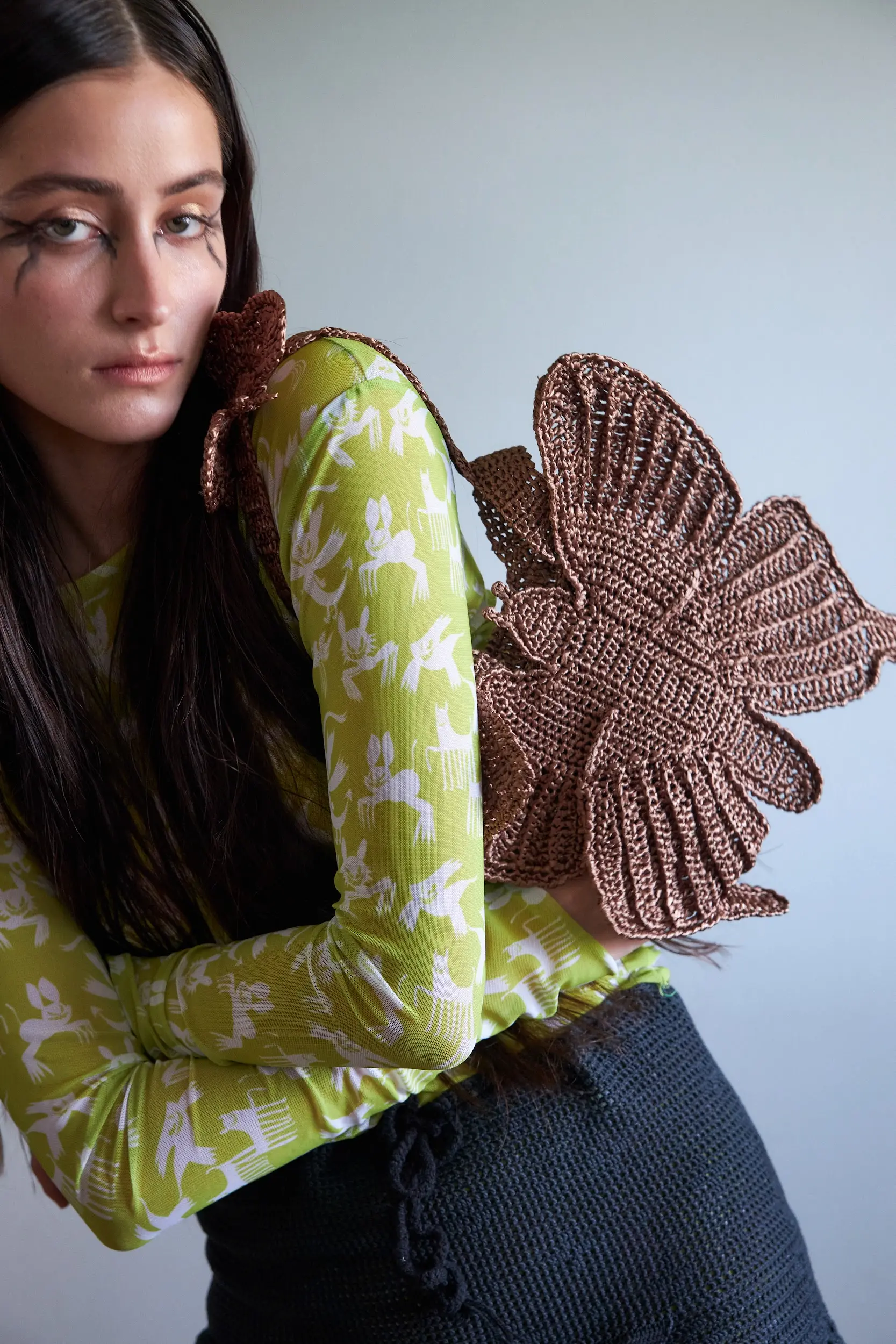 Сумка держит форму и выглядит скульптурно. Крылья рельефные, с чётким плетёным рисунком, будто броня из ниток. Цвет — как кора дерева после дождя.